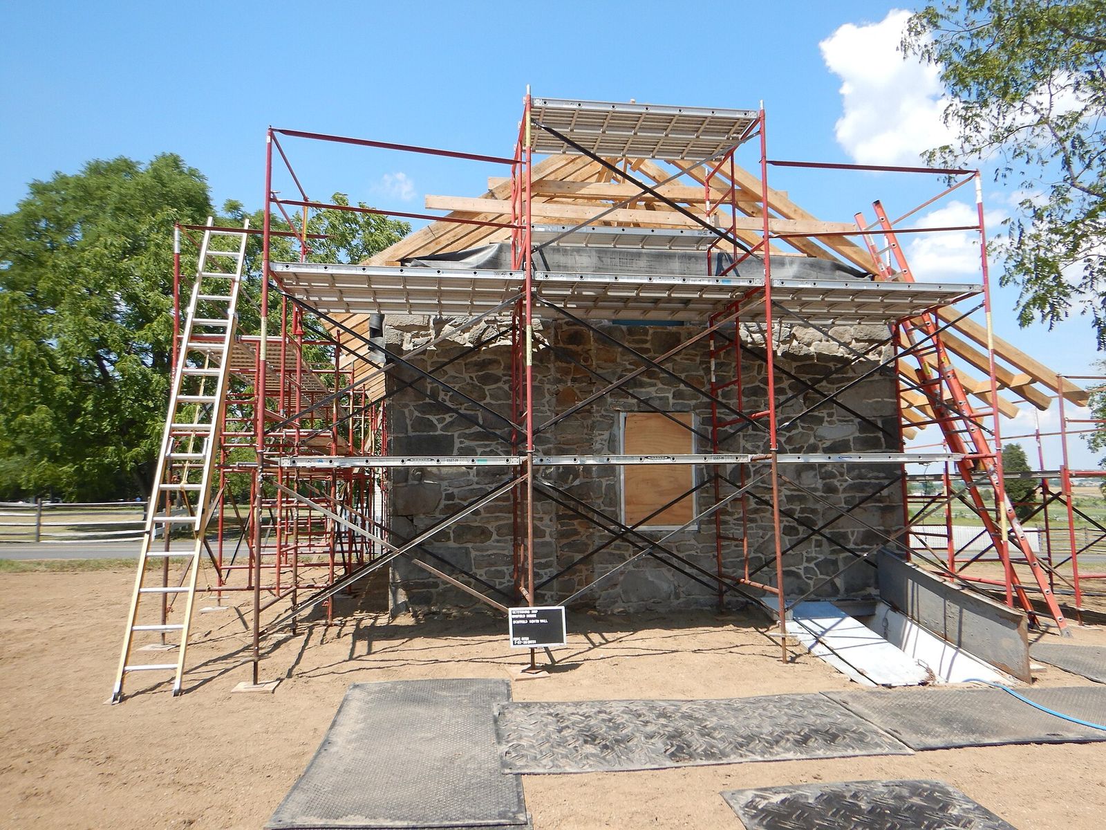 Scaffolding around a stone building during a steep roof replacement